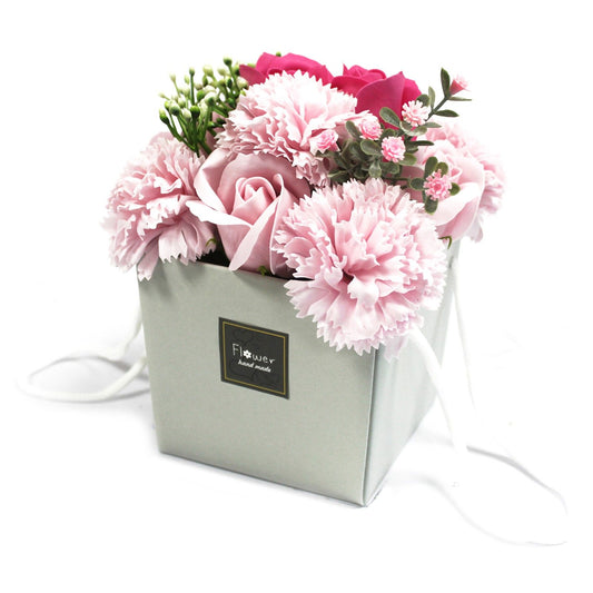 Bouquet of pink flowers in a box with a visible brand label on a white background