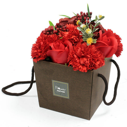 Brown gift box with red flowers and a visible brand label on a white background