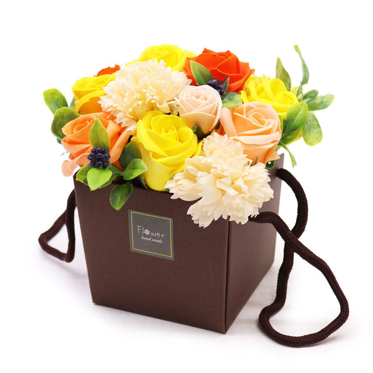 Floral arrangement in a brown box with a visible brand label on a white background