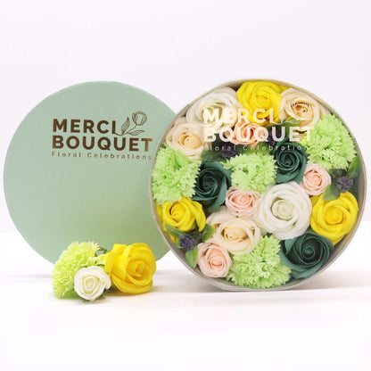 Floral arrangement in a round box with 'Merci Bouquet' branding on a white background