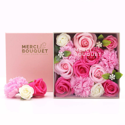 Pink and white flowers in a box with 'Merci Bouquet' branding.
