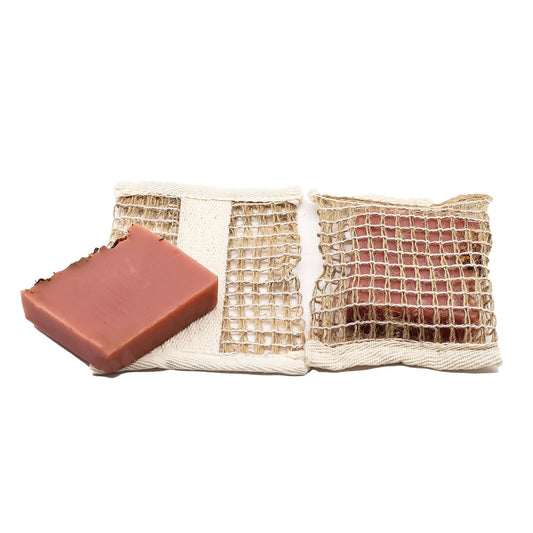 Two bars of soap in a mesh bag on a white background
