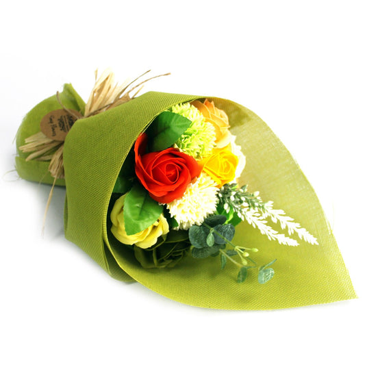 Bouquet of flowers wrapped in green paper on a white background
