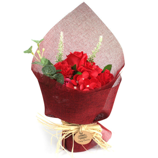 Bouquet of red flowers wrapped in red paper with a white background
