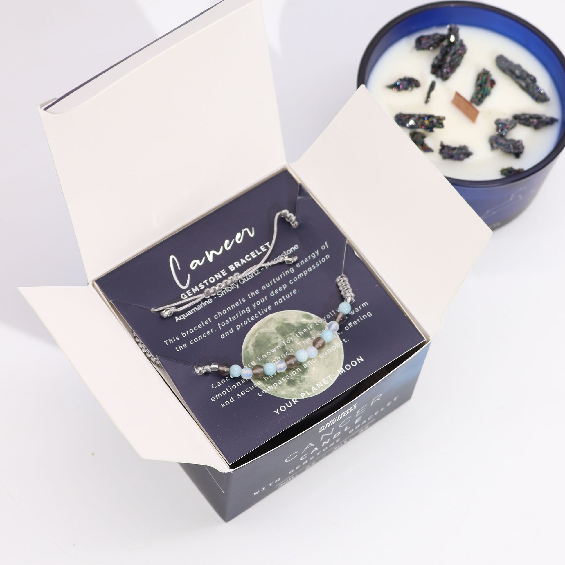 Zodiac Crystal Candle Cancer with Gemstone Bracelet boxed is beautifully presented in a midnight blue glass jar adorned with silver-embossed star sign constellations. 