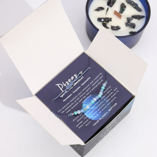 Zodiac Crystal Candle Pisces with Gemstone Bracelet is beautifully presented in a midnight blue glass jar adorned with silver-embossed star sign constellations.