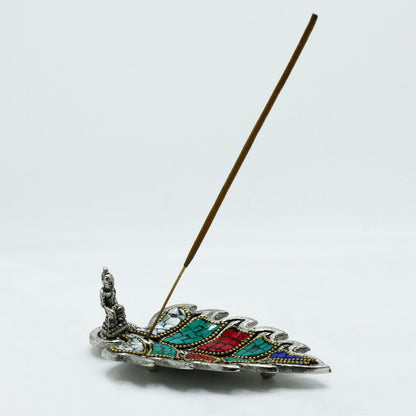 Decorative incense holder with a feather design on a white background