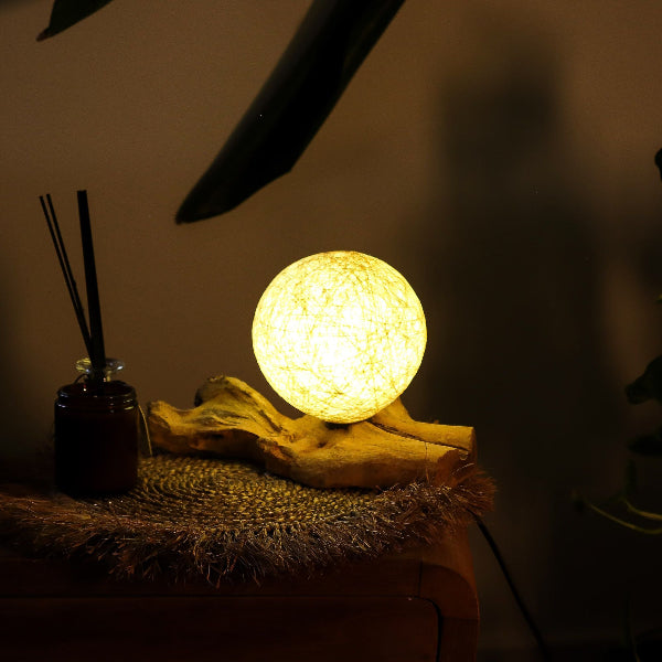 Decorative lamp with diffuser on a textured surface in a dimly lit setting