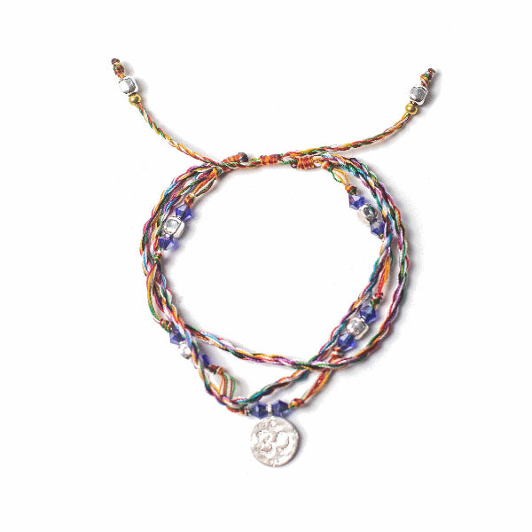 Multicolored braided bracelet with a silver charm on a white background