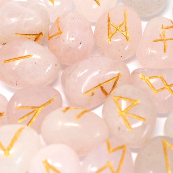 Pink beads with gold symbols on a white background