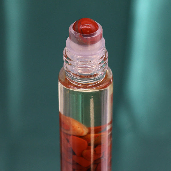 Roll-on bottle with red cap and visible contents against a green background