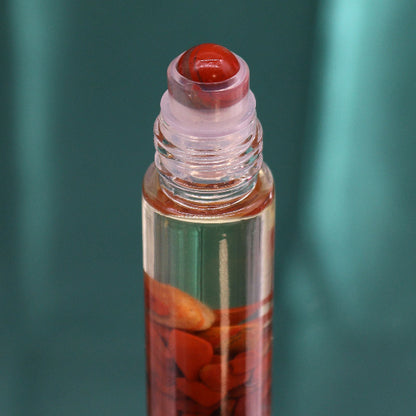 Roll-on bottle with red cap and visible contents against a green background
