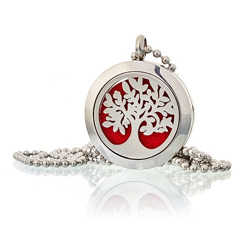 Silver pendant with red center and tree design on a white background