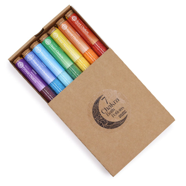 Set of colorful candles in a cardboard box with '7 Chakra Balms' branding.