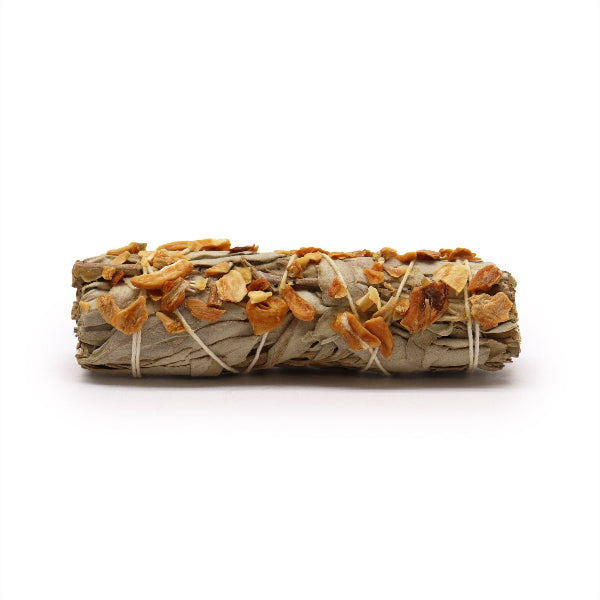 Rolled sage smudge stick with orange and white elements on a white background