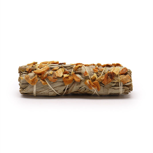 Rolled sage smudge stick with orange and white elements on a white background