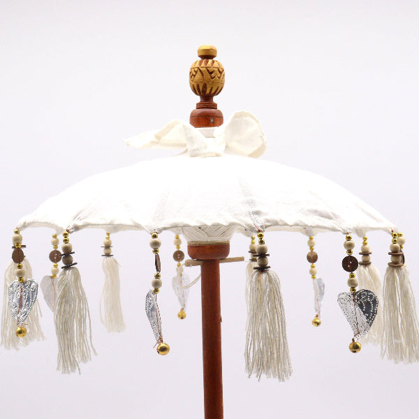 Decorative umbrella with tassels and beads on a white background