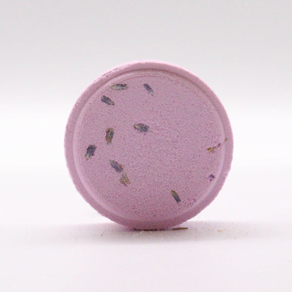 Purple bath bomb with specks on a white background