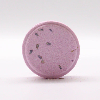 Purple bath bomb with specks on a white background