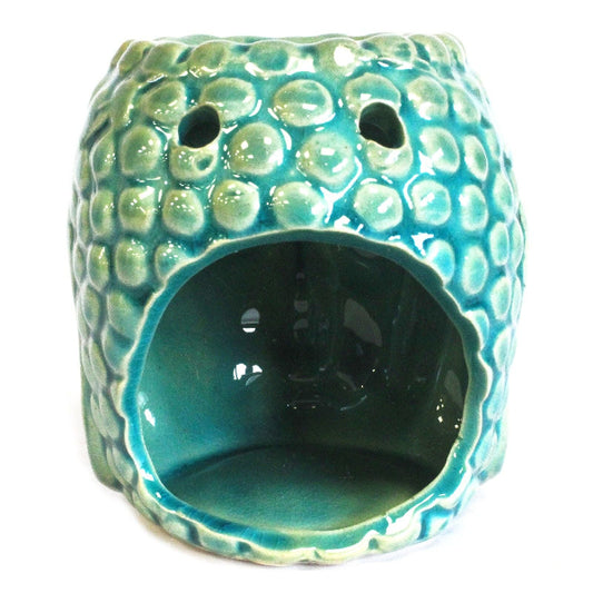 Turquoise ceramic oil burner with textured surface on a white background