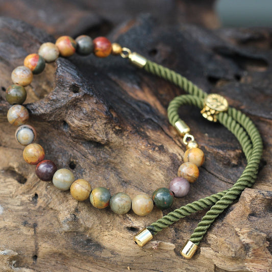 Two bracelets with beaded and braided designs on a wooden surface