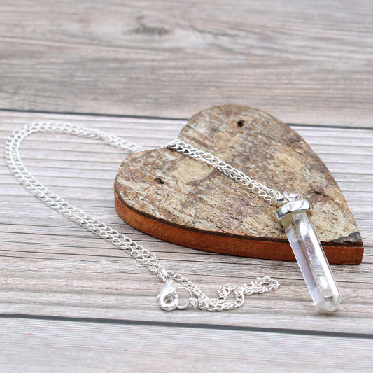 Crystal necklace on a wooden surface with a heart-shaped stone