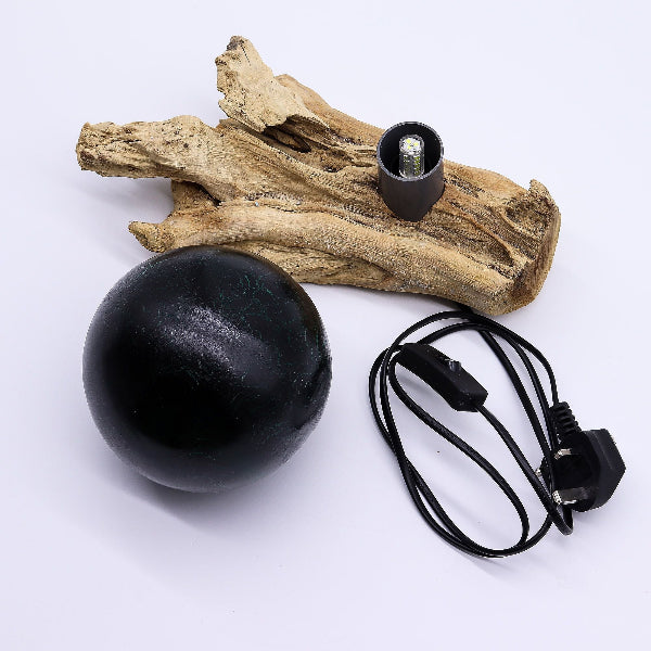 Black spherical object with a cord and plug on a white background