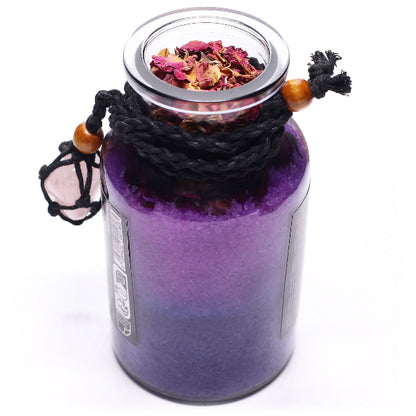 Purple glass jar with a lid containing dried flowers on a white background