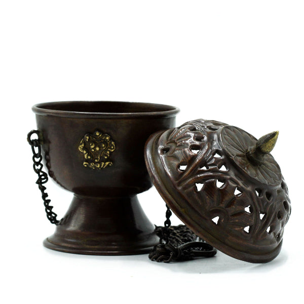 Bronze incense burner with decorative lid on a white background