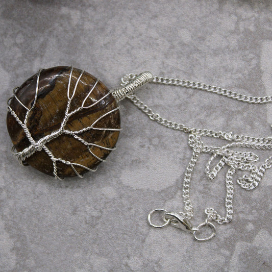 Necklace with a tree-shaped pendant on a gray surface