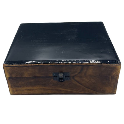 Wooden box with a black lid on a white background