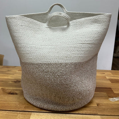 Woven basket with two-tone design on a wooden surface
