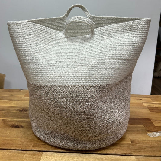 Woven basket with two-tone design on a wooden surface