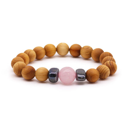 Wooden beaded bracelet with a pink stone on a white background