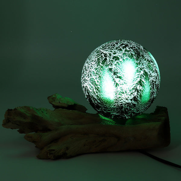 Glass orb with a green light on a dark background
