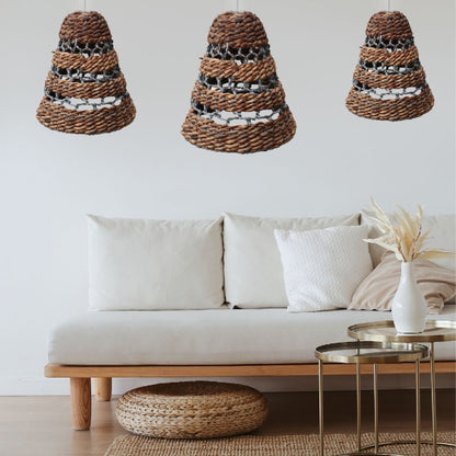 Three woven pendant lights hanging above a white sofa with decorative pillows and a small table.
