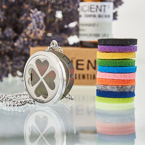 Silver locket with heart design and colorful hair ties on a reflective surface.