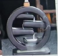 Metallic circular object on a black stand with a blurred background