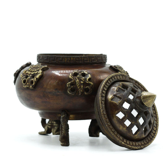 Decorative bronze censer with intricate designs on a white background