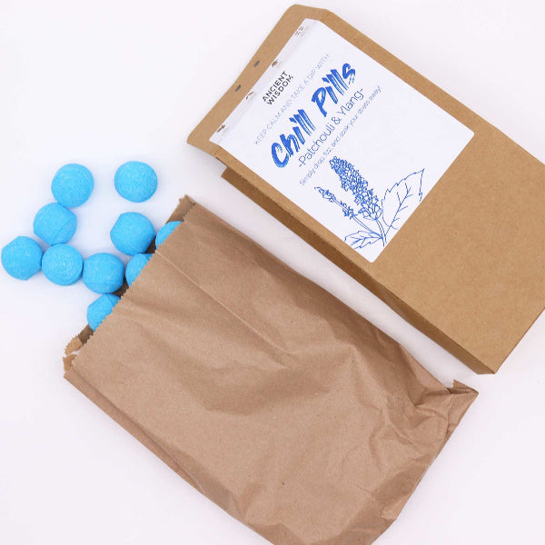 Blue balls in an open brown paper bag with a branded label on a white background