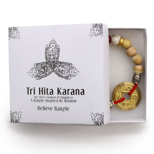 Tri Hita Karana Believe Bangle in a white box with decorative patterns
