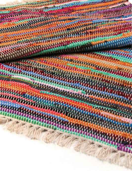 Multicolored woven rug with tassels on a white background