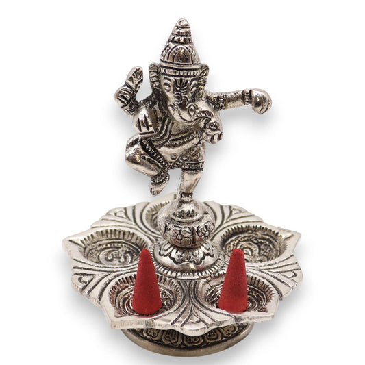 Decorative metal incense holder with red cones on a white background