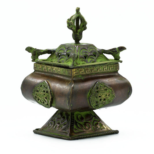 Decorative bronze censer with green patina on a white background