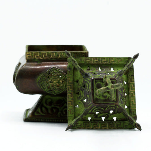 Decorative green metal box with intricate designs on a white background