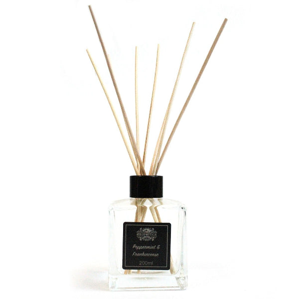 Clear diffuser bottle with wooden sticks on a white background