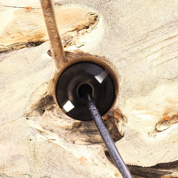 Black cable with a plug inserted into a wooden socket.