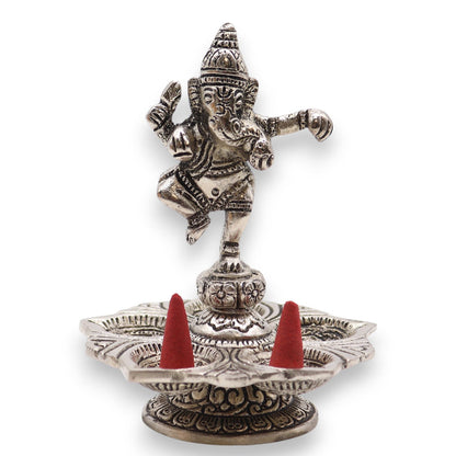 Decorative metal incense holder with red cones on a white background