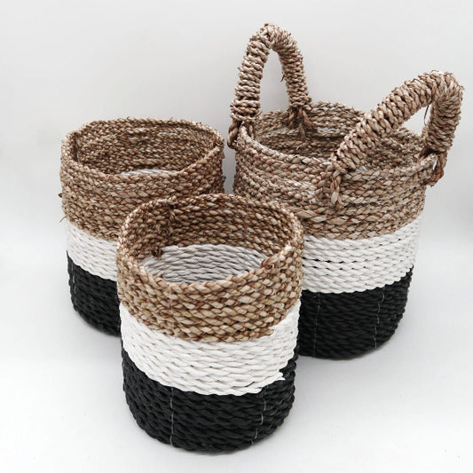 Three woven baskets with black, white, and natural color patterns on a light background