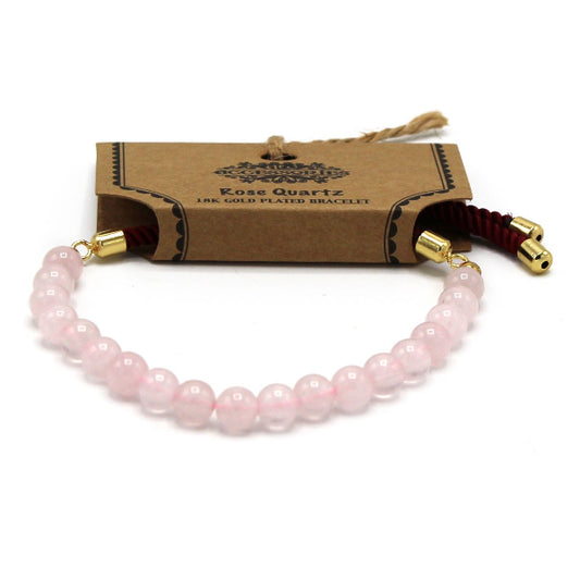 Rose Quartz bracelet with gold accents on a white background